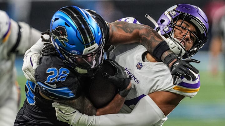 Detroit Lions running back Jahmyr Gibbs (26) fights the tackle by Minnesota Vikings safety Camryn Bynum (24) 