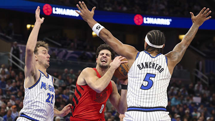 Nov 10, 2025; Orlando, Florida, USA; Portland Trail Blazers forward Deni Avdija (8) drives to the basket past Orlando Magic forward Franz Wagner (22) and forward Paolo Banchero (5) in the first quarter  at Kia Center. Mandatory Credit: Nathan Ray Seebeck-Imagn Images