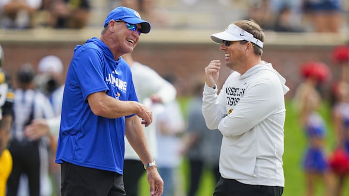 Sep 6, 2025; Columbia, Missouri, USA; Kansas Jayhawks head coach Lance Leipold talks with Missouri Tigers head coach Eliah Drinkwitz prior to a game at Faurot Field at Memorial Stadium. Mandatory Credit: Jay Biggerstaff-Imagn Images