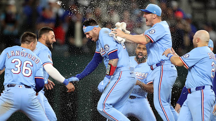 Apr 6, 2025; Arlington, Texas, USA; Texas Rangers catcher Jonah Heim (28) and his teammates celebrate after he singled in the winning run in the bottom of the ninth inning against the Tampa Bay Rays at Globe Life Field. 