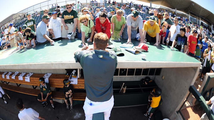 Mar 13, 2011; Phoenix, AZ, USA; Oakland Athletics pitcher Dallas Braden (51) signs autographs for fans prior to the game against the Colorado Rockies in a game at Phoenix Municipal Stadium. Mandatory Credit: Christopher Hanewinckel-Imagn Images