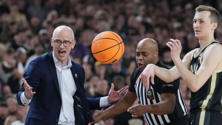 Connecticut Huskies head coach Dan Hurley is pulled back by the referee during the Men's NCAA national championship game against the Purdue Boilermakers at State Farm Stadium in Glendale on April 8, 2024.
