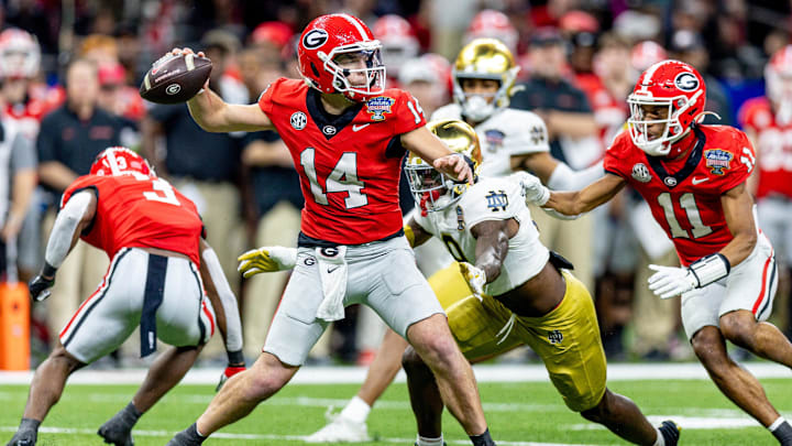 Jan 2, 2025; New Orleans, LA, USA;  Georgia Bulldogs quarterback Gunner Stockton (14) passes against Notre Dame Fighting Irish defensive lineman RJ Oben (9) during the second half at Caesars Superdome. Mandatory Credit: Stephen Lew-Imagn Images