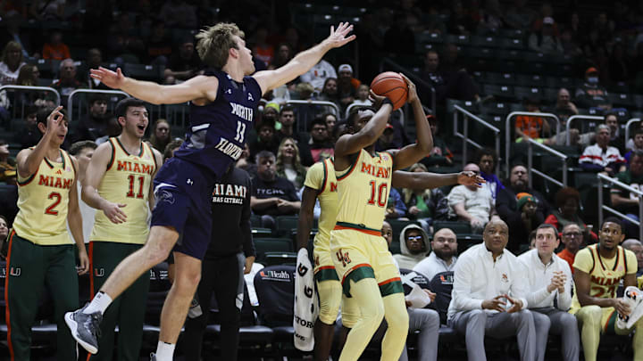 Dec 29, 2023; Coral Gables, Florida, USA; Miami Hurricanes guard Paul Djobet (10) shoots the basketball against North Florida Ospreys guard Oscar Berry (33) during the second half at Watsco Center. Mandatory Credit: Sam Navarro-Imagn Images