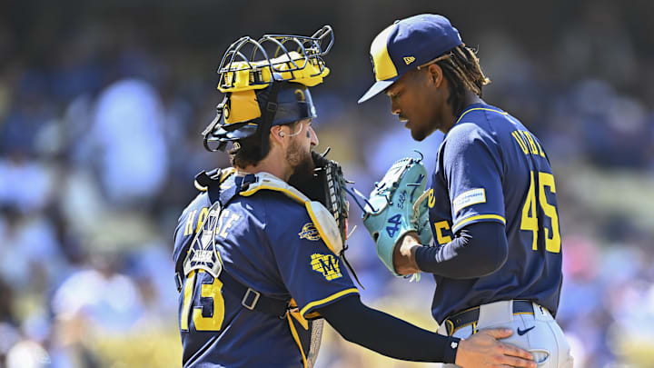 Los Angeles, California, USA; Milwaukee Brewers catcher Eric Haase (13) and pitcher Abner Uribe (45) meet at the mound against the Los Angeles Dodgers during the ninth inning at Dodger Stadium.