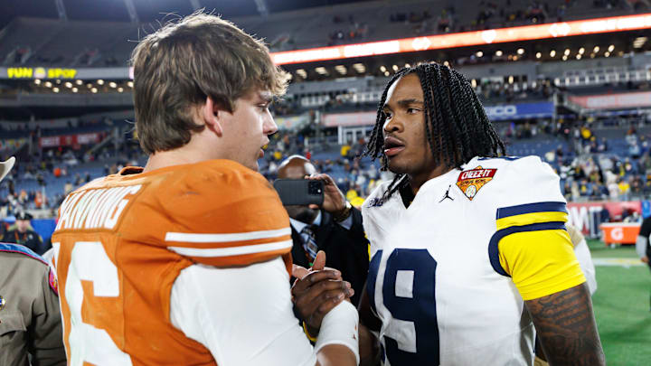 Orlando, FL, USA; Texas Longhorns quarterback Arch Manning (16) and Michigan Wolverines quarterback Bryce Underwood (19) shake hands after a game at Camping World Stadium.