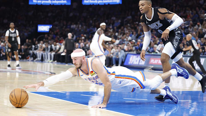 Oct 30, 2024; Oklahoma City, Oklahoma, USA; Oklahoma City Thunder guard Alex Caruso (9) dives for a loose ball in front of San Antonio Spurs forward Keldon Johnson (0) during the second quarter at Paycom Center. Mandatory Credit: Alonzo Adams-Imagn Images