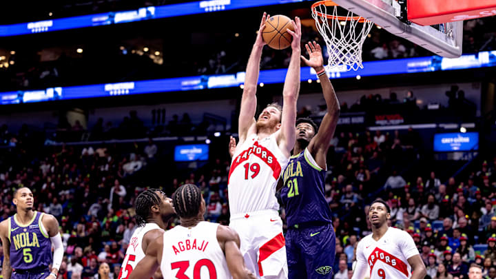 Nov 27, 2024; New Orleans, Louisiana, USA;  Toronto Raptors center Jakob Poeltl (19) grabs a rebound against New Orleans Pelicans center Yves Missi (21) during the first half at Smoothie King Center. Mandatory Credit: Stephen Lew-Imagn Images
