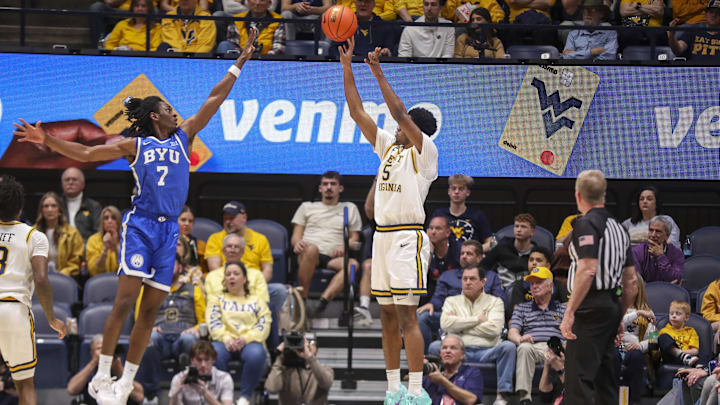 Feb 28, 2026; Morgantown, West Virginia, USA; West Virginia Mountaineers forward DJ Thomas (5) shoots a three point shot over BYU Cougars forward Khadim Mboup (7) during the first half at Hope Coliseum. Mandatory Credit: Ben Queen-Imagn Images Feb 28, 2026; Morgantown, West Virginia, USA; West Virginia Mountaineers forward DJ Thomas (5) shoots a three point shot over BYU Cougars forward Khadim Mboup (7) during the first half at Hope Coliseum. Mandatory Credit: Ben Queen-Imagn Images