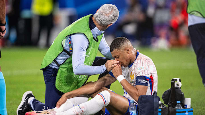 Kylian Mbappé siendo atendido luego del fuerte golpe sufrido en la nariz