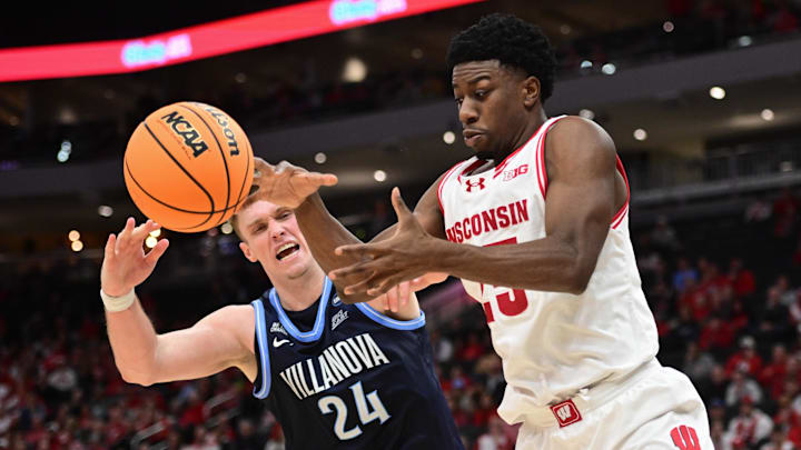 Dec 19, 2025; Milwaukee, Wisconsin, USA; Wisconsin Badgers guard John Blackwell (25) and Villanova Wildcats forward Duke Brennan (24) reach for a rebound in the second half at the Fiserv Forum.