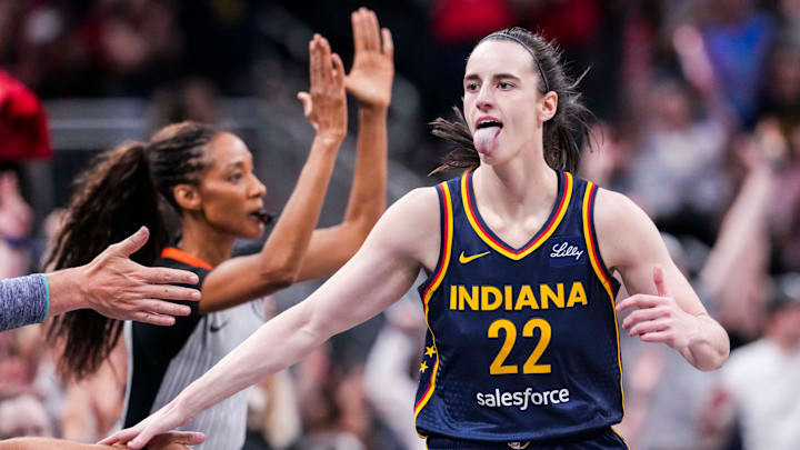 Indiana Fever guard Caitlin Clark (22) high-fives fans after scoring a 3-pointer Saturday, June 14, 2025, during a game between the Indiana Fever and the New York Liberty at Gainbridge Fieldhouse in Indianapolis.