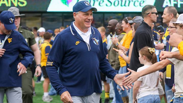 Sep 27, 2025; Morgantown, West Virginia, USA; West Virginia Mountaineers head coach Rich Rodriguez walks on the field and greets fans before their game against the Utah Utes at Milan Puskar Stadium. Mandatory Credit: Ben Queen-Imagn Images Sep 27, 2025; Morgantown, West Virginia, USA; West Virginia Mountaineers head coach Rich Rodriguez walks on the field and greets fans before their game against the Utah Utes at Milan Puskar Stadium. Mandatory Credit: Ben Queen-Imagn Images