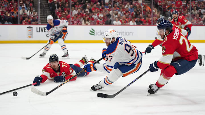 Jun 17, 2025; Sunrise, Florida, USA; Florida Panthers defenseman Niko Mikkola (77) deflects the puck against Edmonton Oilers center Connor McDavid (97) during the third period in game six of the 2025 Stanley Cup Final at Amerant Bank Arena. Mandatory Credit: Jim Rassol-Imagn Images