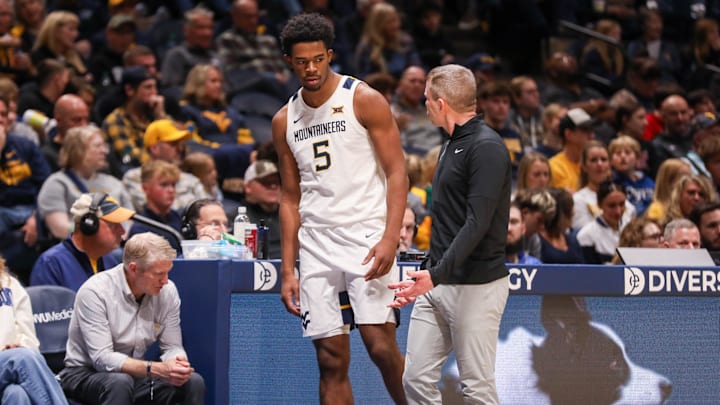 Nov 30, 2025; Morgantown, West Virginia, USA; West Virginia Mountaineers forward DJ Thomas (5) talks to West Virginia Mountaineers head coach Ross Hodge during the second half against the Mercyhurst Lakers at Hope Coliseum. Mandatory Credit: Ben Queen-Imagn Images