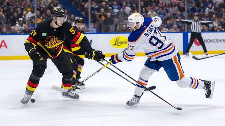 Jan 18, 2025; Vancouver, British Columbia, CAN; Edmonton Oilers forward Connor McDavid (97) shoots around Vancouver Canucks defenseman Tyler Myers (57) in the first period at Rogers Arena. Mandatory Credit: Bob Frid-Imagn Images