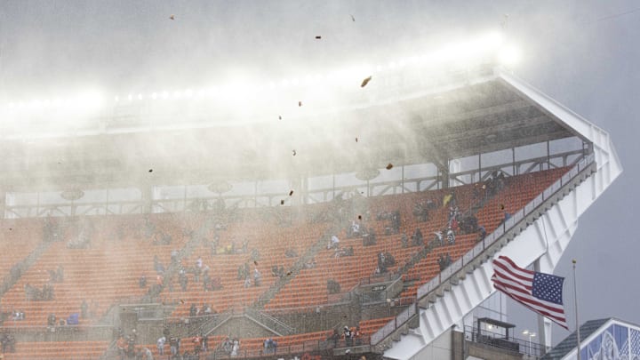 Nov 15, 2020; Cleveland, Ohio, USA; Debris flies through the air as rain and hail falls during the national anthem before the game between the Cleveland Browns and Houston Texans at FirstEnergy Stadium. The game has been delayed due to lightning. Mandatory Credit: Scott Galvin-Imagn Images