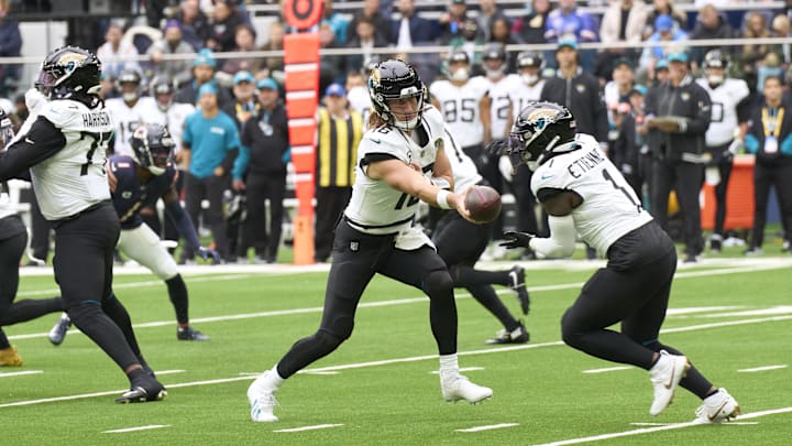 Oct 13, 2024; London, United Kingdom; Jacksonville Jaguars quarterback Trevor Lawrence (16) passes to 	Jacksonville Jaguars running back Travis Etienne Jr. (1) during the first half of an NFL International Series game at Tottenham Hotspur Stadium. Mandatory Credit: Peter van den Berg-Imagn Images