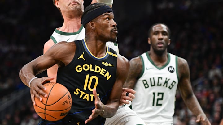 Feb 10, 2025; Milwaukee, Wisconsin, USA; Golden State Warriors forward Jimmy Butler (10) drives for the basket against Milwaukee Bucks guard Taurean Prince (12) and center Brook Lopez (11) in the first quarter at Fiserv Forum. Mandatory Credit: Benny Sieu-Imagn Images