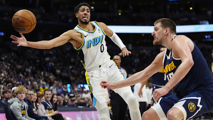 Apr 6, 2025; Denver, Colorado, USA; Indiana Pacers guard Tyrese Haliburton (0) and Denver Nuggets center Nikola Jokic (15) reach for the ball in the second half at Ball Arena. Mandatory Credit: Ron Chenoy-Imagn Images