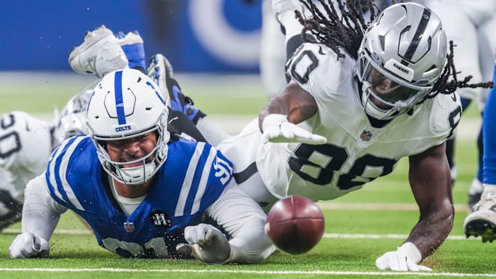 Indianapolis Colts defensive end JT Tuimoloau (91) and Las Vegas Raiders tight end Ian Thomas (80) go for the ball after a blocked punt Sunday, Oct. 5, 2025, during a game against the Las Vegas Raiders at Lucas Oil Stadium in Indianapolis.