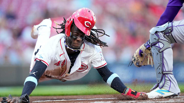 Cincinnati Reds shortstop Elly De La Cruz (44) dives across home plate on a steal attempt but is tagged out by Colorado Rockies catcher Elias Díaz (35) for the final out of the first inning of the MLB National League game between the Cincinnati Reds and the Colorado Rockies at Great American Ball Park in downtown Cincinnati on Monday, July 8, 2024. The score was 0-0 after three innings.