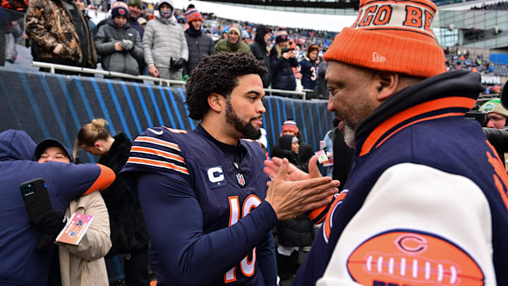 Caleb Williams greets his father, Carl Williams, on the sidelines before last year's game with the Lions.