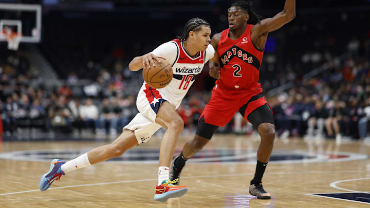 Oct 11, 2024; Washington, District of Columbia, USA; Washington Wizards forward Kyshawn George (18) drives to the basket as Toronto Raptors forward Jonathan Mogbo (2) defends in the second quarter at Capital One Arena. Mandatory Credit: Geoff Burke-Imagn Images