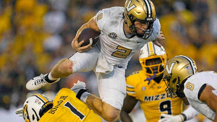 Sep 21, 2024; Columbia, Missouri, USA; Vanderbilt Commodores quarterback Diego Pavia (2) leaps over Missouri Tigers safety Marvin Burks Jr. (1) during overtime at Faurot Field at Memorial Stadium. Mandatory Credit: Jay Biggerstaff-Imagn Images