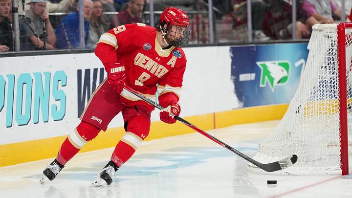 Apr 9, 2026; Las Vegas, Nevada, UNITED STATES; Denver Pioneers defenseman Boston Buckberger (9) moves the puck in the third period against the Michigan Wolverines in the semifinals of the NCAA men's ice hockey Frozen Four at T-Mobile Arena. Mandatory Credit: Lucas Peltier-Imagn Images