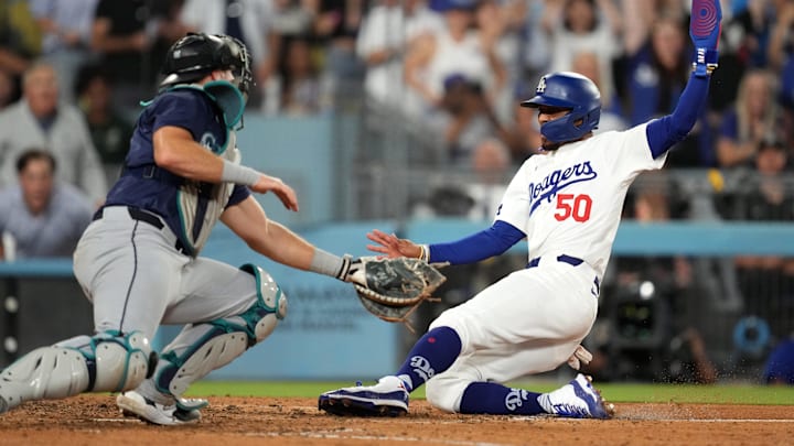 Seattle Mariners catcher Cal Raleigh tags out a runner during a game against the Los Angeles Dodgers on Aug. 20 at Dodger Stadium. Seattle Mariners catcher Cal Raleigh tags out a runner during a game against the Los Angeles Dodgers on Aug. 20 at Dodger Stadium.