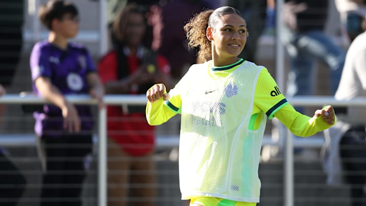 Washington Spirit forward Trinity Rodman warms up on the sidelines during the first half against Racing Louisville FC.