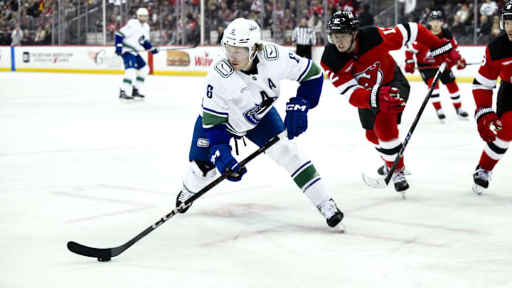 Vancouver Canucks right wing Brock Boeser (6) controls the puck as New Jersey Devils defenseman Simon Nemec (17) defends: John Jones-Imagn Images