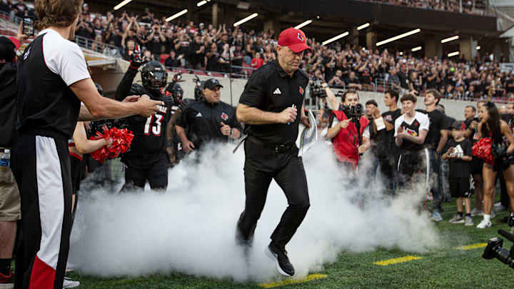 Head Coach, Jeff Brohm, running onto the field for his first home game back in The Ville