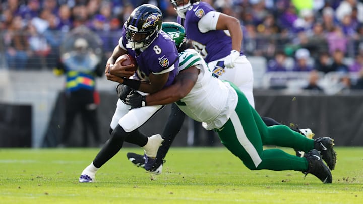 Nov 23, 2025; Baltimore, Maryland, USA; Baltimore Ravens quarterback Lamar Jackson (8) rushes and is tackled by New York Jets defensive tackle Jowon Briggs (91) during the second quarter at M&T Bank Stadium. Mandatory Credit: Peter Casey-Imagn Images