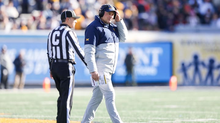 Nov 29, 2025; Morgantown, West Virginia, USA; West Virginia Mountaineers head coach Rich Rodriguez walks off the field after questioning a call with a referee during the first quarter against the Texas Tech Red Raiders at Milan Puskar Stadium. Mandatory Credit: Ben Queen-Imagn Images