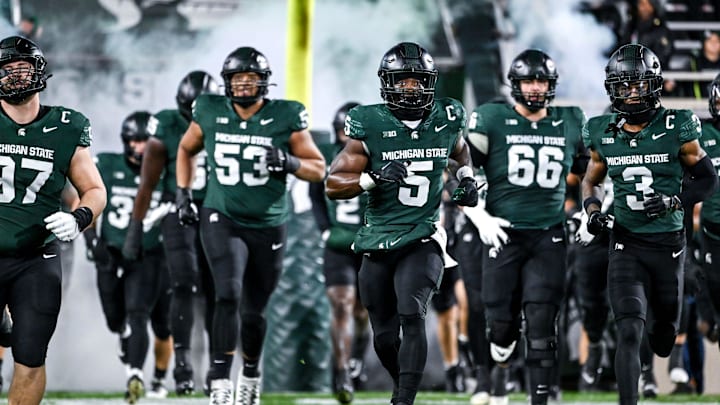 Michigan State's Nathan Carter, center, and the team take the field before the football game against Purdue on Friday, Nov. 22, 2024, at Spartan Stadium in East Lansing.