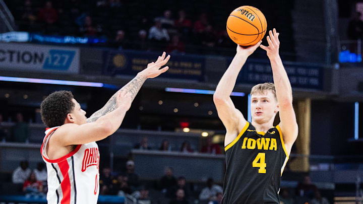 Mar 12, 2025; Indianapolis, IN, USA; Iowa Hawkeyes guard Josh Dix (4) shoots the ball while Ohio State Buckeyes guard John Mobley Jr. (0) defends in the first half  at Gainbridge Fieldhouse. Mandatory Credit: Trevor Ruszkowski-Imagn Images