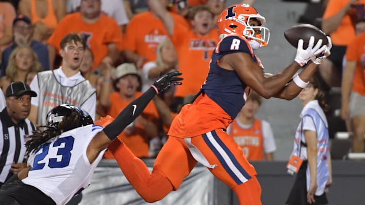 Aug 29, 2024; Champaign, Illinois, USA;  Illinois Fighting Illini wide receiver Malik Elzy (8) catches a touchdown in from of Eastern Illinois Panthers defensive back Isaiah Houi (23) during the first half at Memorial Stadium. Mandatory Credit: Ron Johnson-Imagn Images