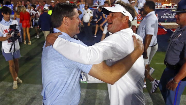 Sep 13, 2025; Oxford, Mississippi, USA; Mississippi Rebels head coach Lane Kiffin (right) reacts with Vice Chancellor for Intercollegiate Athletics Keith Carter (left) after defeating the Arkansas Razorback at Vaught-Hemingway Stadium. Mandatory Credit: Petre Thomas-Imagn Images