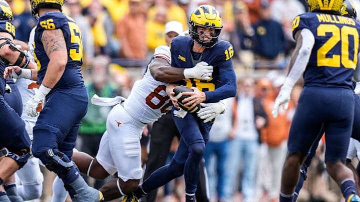 Michigan quarterback Davis Warren (16) is sacked by Texas linebacker Barryn Sorrell (88)