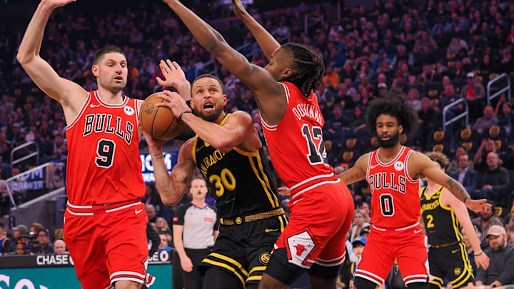 Mar 7, 2024; San Francisco, California, USA; Golden State Warriors guard Stephen Curry (30) drives between Chicago Bulls center Nikola Vucevic (9) and guard Ayo Dosunmu (12) during the first quarter at Chase Center. Mandatory Credit: Kelley L Cox-Imagn Images Mar 7, 2024; San Francisco, California, USA; Golden State Warriors guard Stephen Curry (30) drives between Chicago Bulls center Nikola Vucevic (9) and guard Ayo Dosunmu (12) during the first quarter at Chase Center. Mandatory Credit: Kelley L Cox-Imagn Images