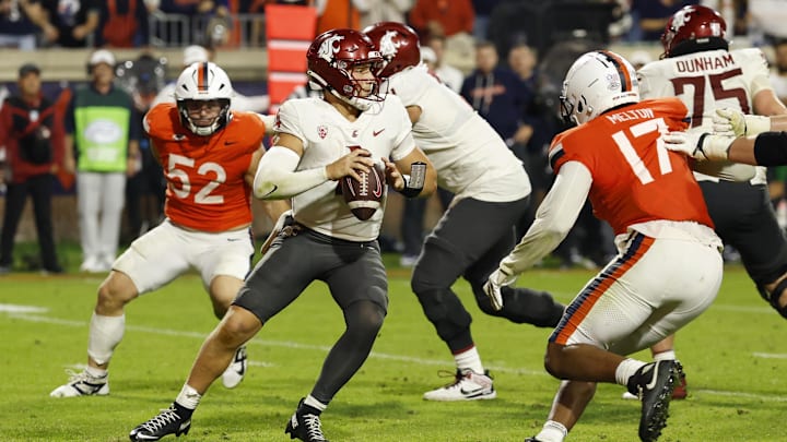 Oct 18, 2025; Charlottesville, Virginia, USA; Washington State Cougars quarterback Zevi Eckhaus (4) scrambles from Virginia Cavaliers defensive end Mitchell Melton (17) Cavaliers defensive lineman Daniel Rickert (52) in the fourth quarter at Scott Stadium. Mandatory Credit: Geoff Burke-Imagn Images