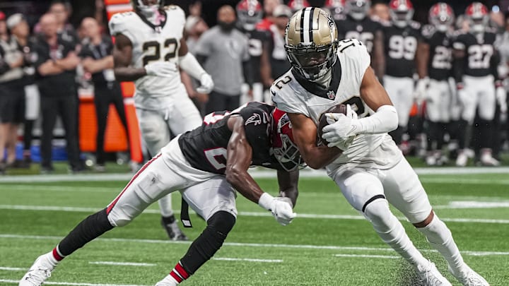 Sep 29, 2024; Atlanta, Georgia, USA; New Orleans Saints wide receiver Chris Olave (12) is tackled by Atlanta Falcons cornerback Dee Alford (20) after catching a pass against the Atlanta Falcons during the fourth quarter at Mercedes-Benz Stadium. Mandatory Credit: Dale Zanine-Imagn Images