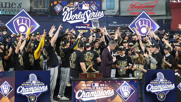 Oct 28, 2026; St. Petersburg, Florida, USA;  Milwaukee Brewers designated hitter Christian Yelich (22) celebrates the Commissioner's Trophy on the podium after defeating the Tampa Bay Rays in game five of the 2026 World Series at Tropicana Field.  Mandatory Credit: Nathan Ray Seebeck-Imagn Images