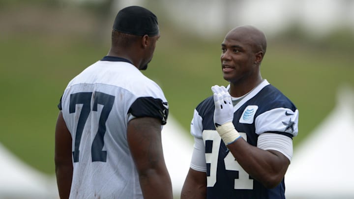 Dallas Cowboys defensive end DeMarcus Ware talks with tackle Tyron Smith at training camp.