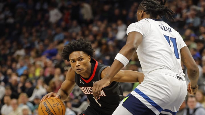 Feb 4, 2024; Minneapolis, Minnesota, USA; Houston Rockets guard Amen Thompson (1) drives around Minnesota Timberwolves forward Naz Reid (11)