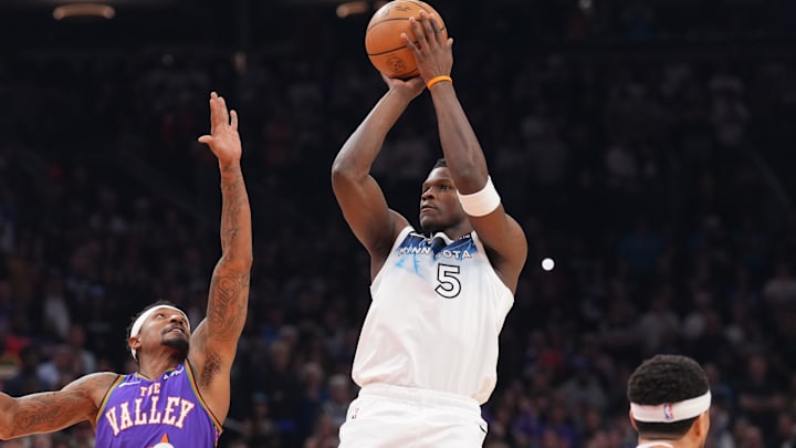 Mar 2, 2025; Phoenix, Arizona, USA; Minnesota Timberwolves guard Anthony Edwards (5) shoots against Phoenix Suns guard Bradley Beal (3) and Phoenix Suns guard Devin Booker (1) during the first half at Footprint Center.