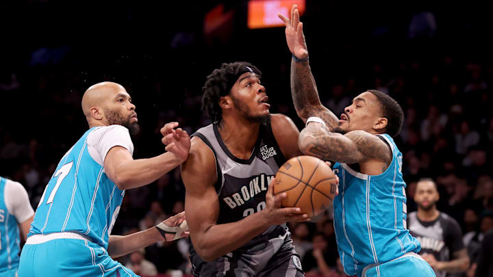 Feb 10, 2025; Brooklyn, New York, USA; Brooklyn Nets center Day'Ron Sharpe (20) controls the ball against Charlotte Hornets forward Taj Gibson (67) and guard DaQuan Jeffries (3) during the third quarter at Barclays Center. Mandatory Credit: Brad Penner-Imagn Images