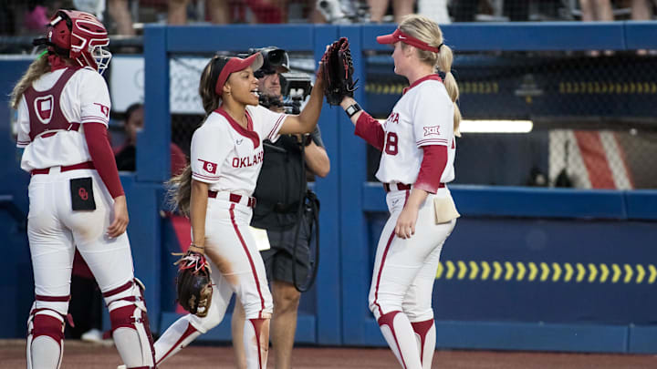 Jun 5, 2024; Oklahoma City, OK, USA;  Oklahoma Sooners outfielder Rylie Boone (0) slaps the glove of starting pitcher Kelly Maxwell (28) as catcher Kinzie Hansen (9)